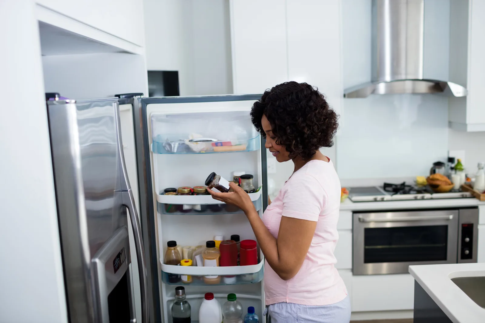 Homeowner in her kitchen with the stove, oven and extractor in daily use